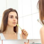 young woman brushes teeth