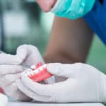 lab tech holds denture